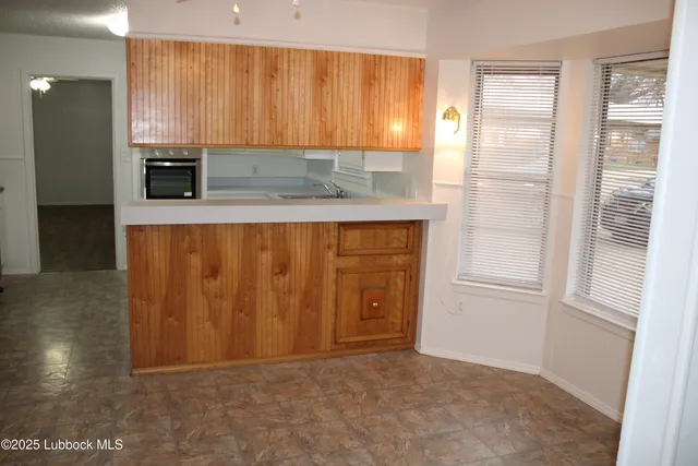 a view of kitchen with wooden floor and cabinets