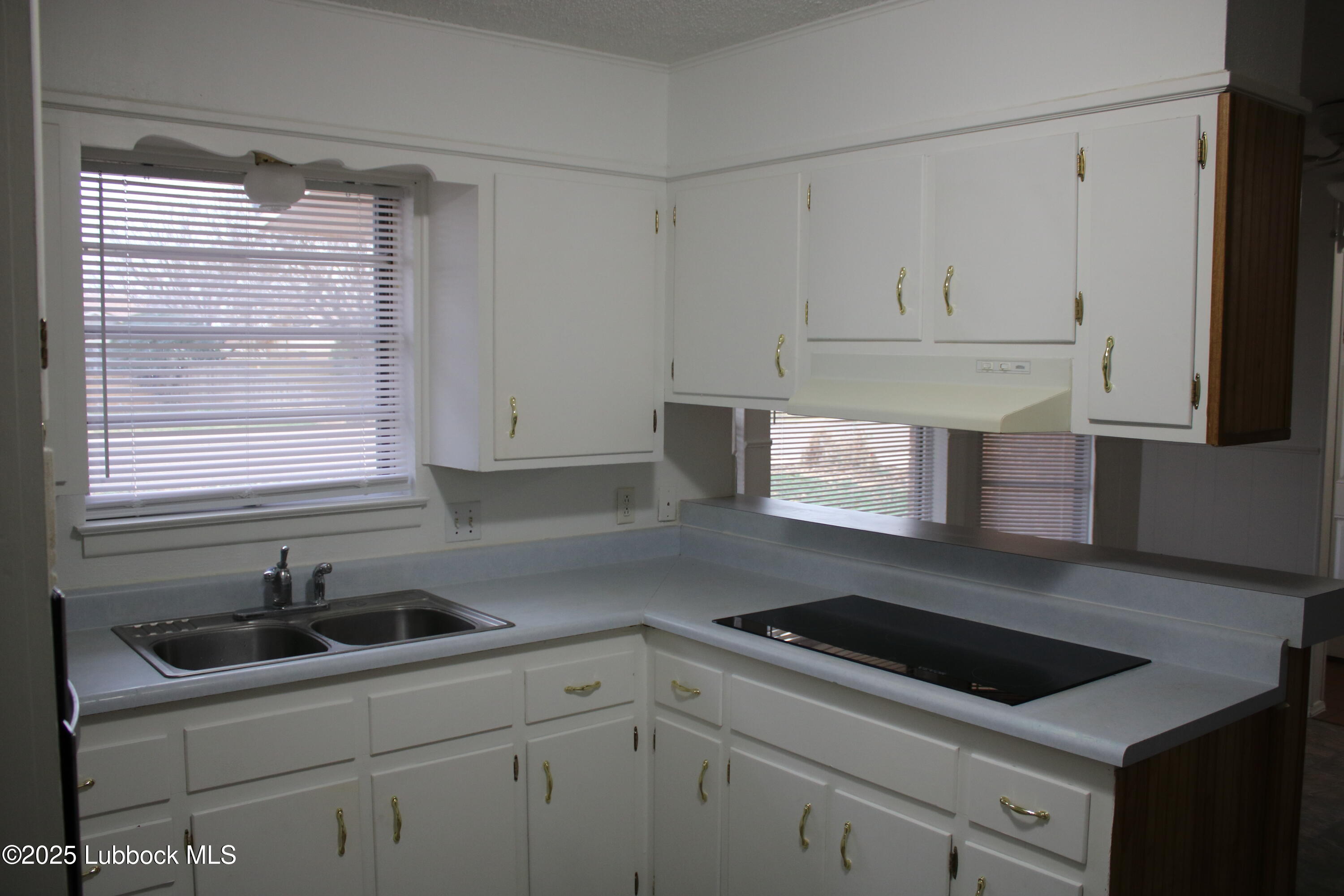 5503 36th Street Lubbock, TX 79407 - Photo 5 of 22 a kitchen with white cabinets appliances a sink and a window