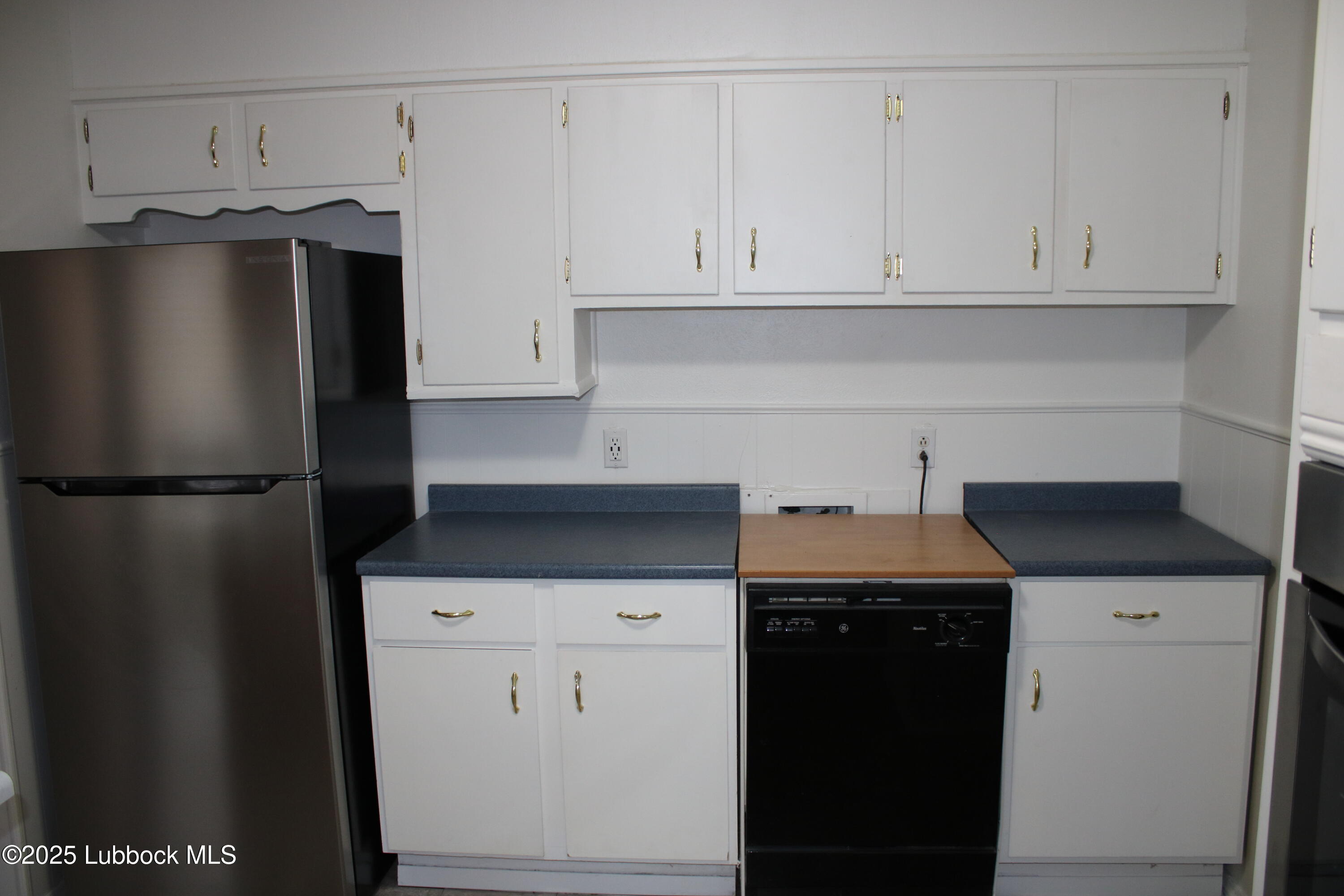 5503 36th Street Lubbock, TX 79407 - Photo 7 of 22 a kitchen with stainless steel appliances granite countertop a refrigerator a stove and a refrigerator with white cabinets