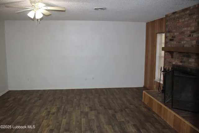 en empty room with wooden floor and chandelier