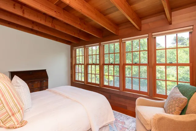 a bedroom with furniture next to a large window