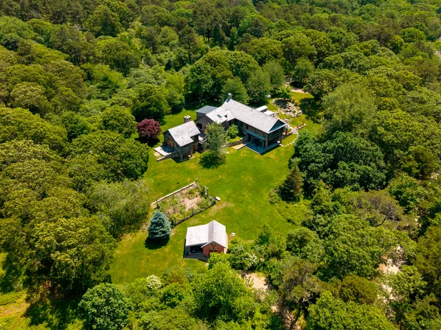 an aerial view of a house with swimming pool and lawn chairs