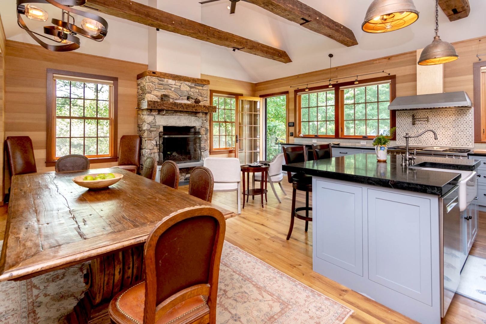 15 Old Farm Road Chilmark, MA 02535 - Photo 8 of 51 a kitchen with granite countertop a stove a sink a dining table and chairs with wooden floor