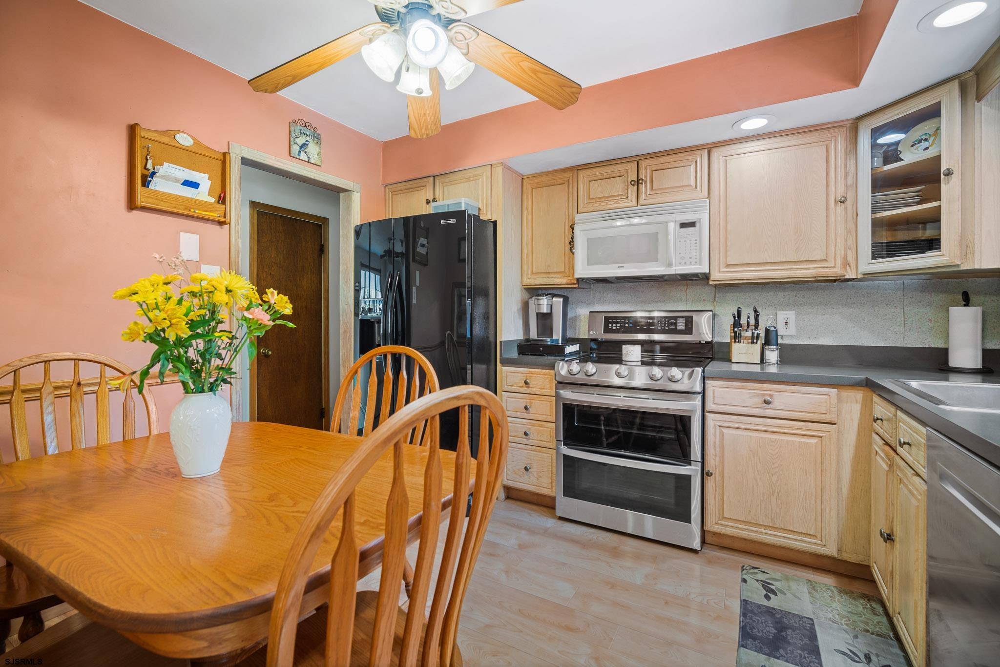 1326 Elwood Road Hammonton, NJ 08037 - Photo 21 of 36 a kitchen with stainless steel appliances granite countertop a refrigerator a stove a sink dishwasher a dining table and chairs with wooden floor