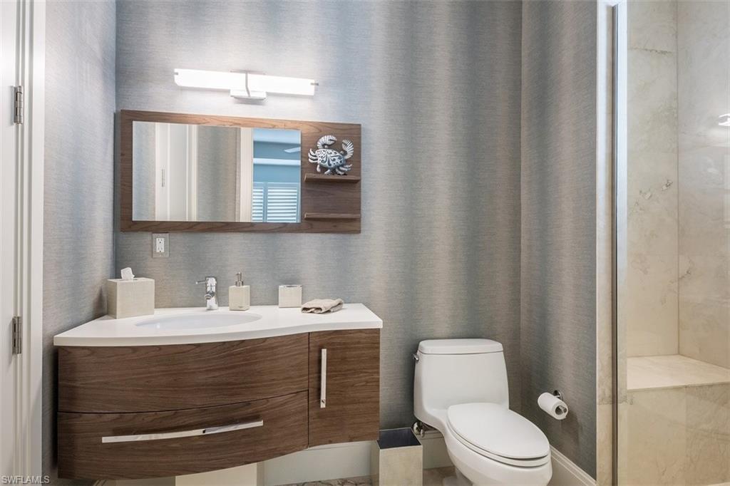 2290 Tarpon Road Naples, FL 34102 - Photo 23 of 35 a bathroom with a sink a toilet and a mirror