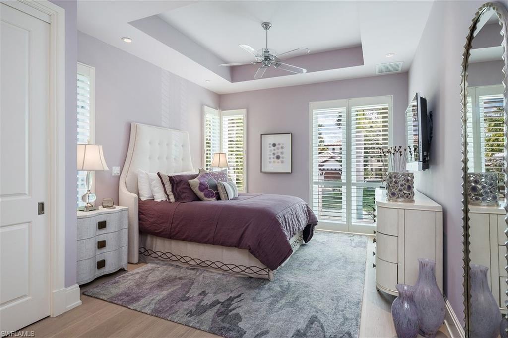 2290 Tarpon Road Naples, FL 34102 - Photo 24 of 35 a spacious bedroom with a large bed and a chandelier