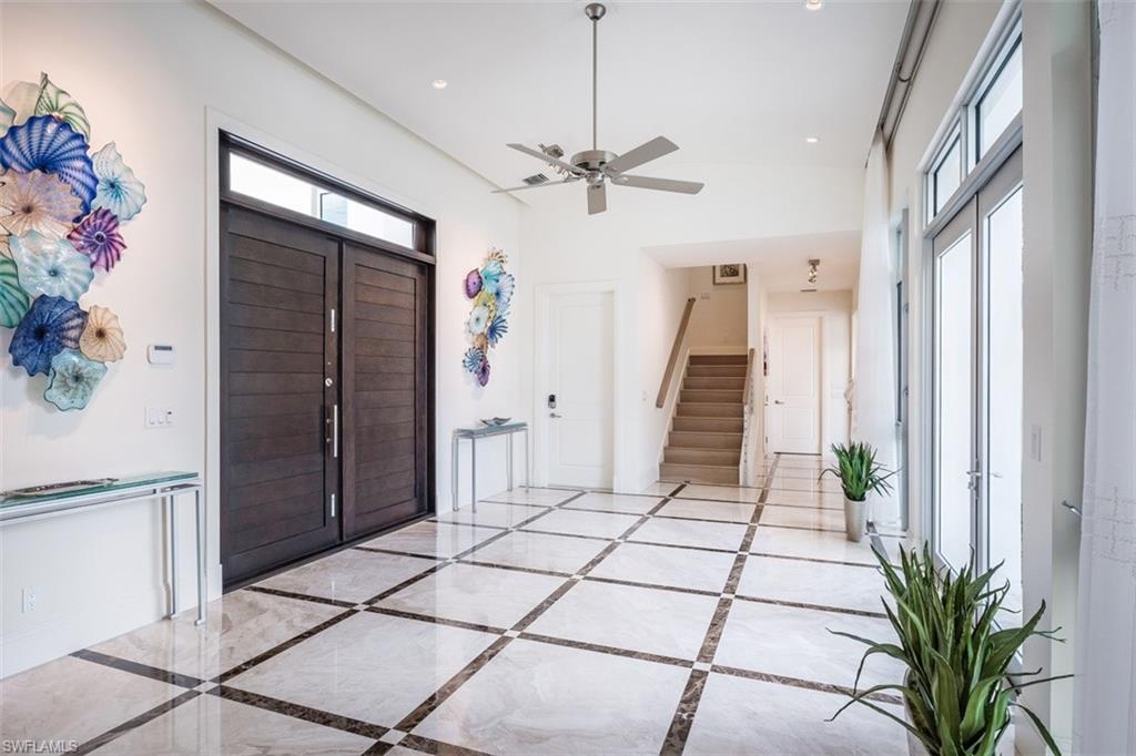2290 Tarpon Road Naples, FL 34102 - Photo 5 of 35 a view of a hallway with stairs and a chandelier