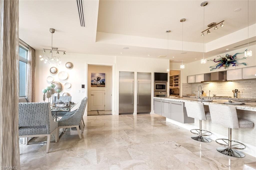 2290 Tarpon Road Naples, FL 34102 - Photo 6 of 35 a large kitchen with stainless steel appliances kitchen island granite countertop a table and chairs in it