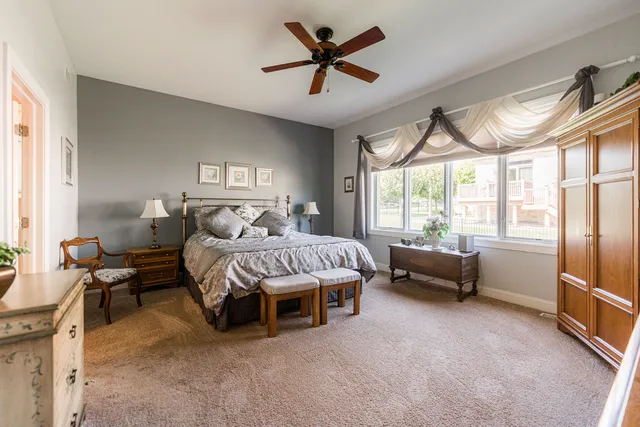 a bedroom with a bed a couch and a chandelier