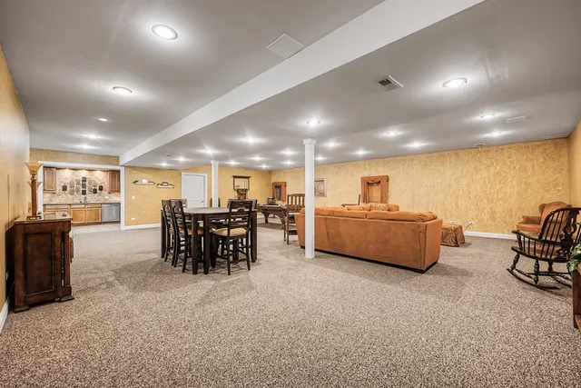 a living room with furniture and kitchen view with a flat screen tv
