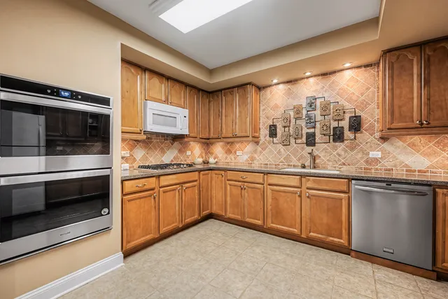 a kitchen with granite countertop stainless steel appliances and wooden cabinets