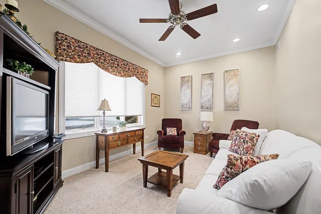 a living room with couches a flat screen tv and kitchen view