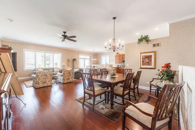 a view of a dining room and livingroom with furniture wooden floor a chandelier