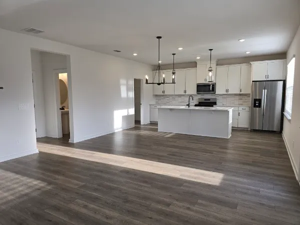 a view of kitchen with wooden floor and refrigerator