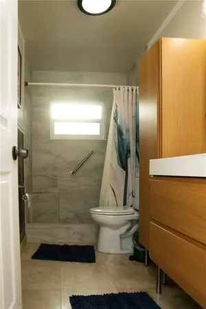 a bathroom with a glass shower door and a window