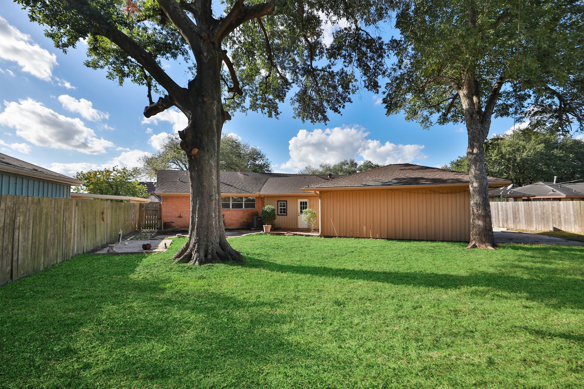 8235 Dover Street Houston, TX 77061 - Photo 33 of 36 a view of a backyard with large trees and a barn with large trees