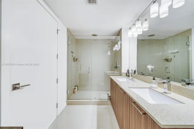 a bathroom with a double vanity sink mirror double and shower