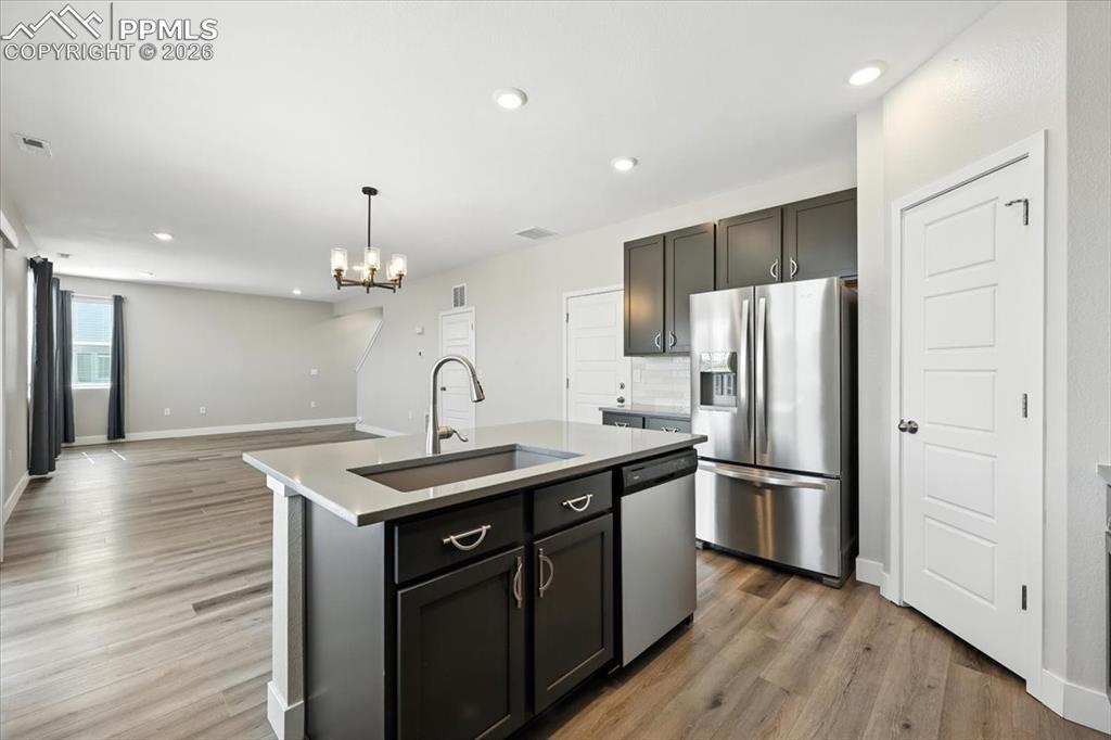 9891 Hidden Ranch Court Peyton, CO 80831 - Photo 13 of 44 a kitchen with stainless steel appliances granite countertop a refrigerator a sink dishwasher a stove with wooden floors