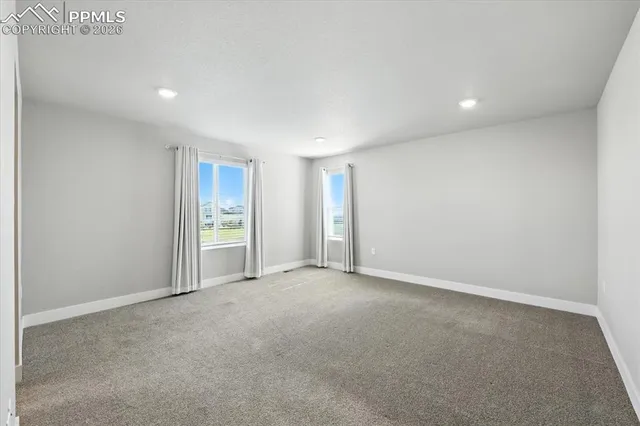 a spacious bedroom with a bed and a lamp