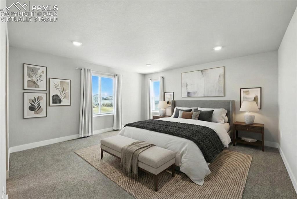 9891 Hidden Ranch Court Peyton, CO 80831 - Photo 20 of 44 a spacious bedroom with a bed and a lamp