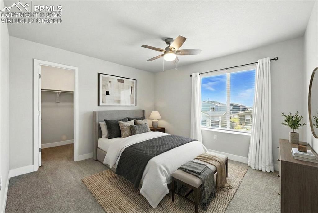 9891 Hidden Ranch Court Peyton, CO 80831 - Photo 32 of 44 a bedroom with a large bed and a chandelier