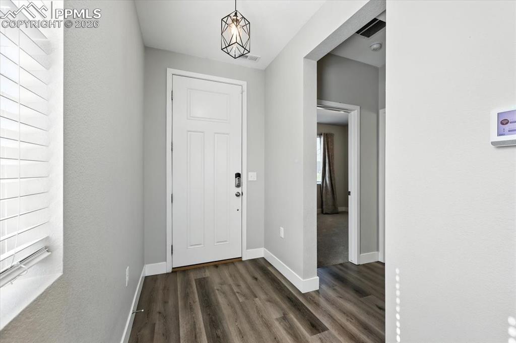 9891 Hidden Ranch Court Peyton, CO 80831 - Photo 5 of 44 a view of a hallway with wooden floor and a bathroom