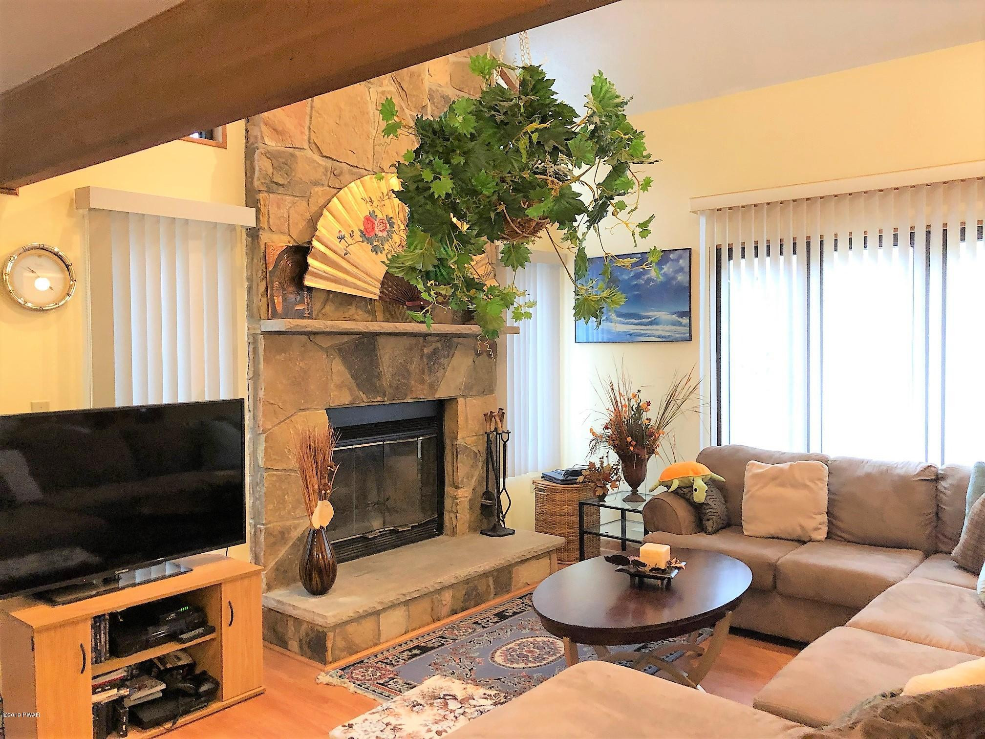 3039 Northgate Road Lake Ariel, PA 18436 - Photo 11 of 57 a living room with furniture a fireplace and a large window