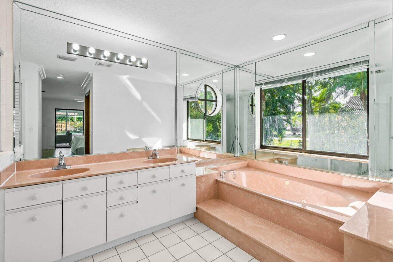 10374 Canoe Brook Circle Boca Raton, FL 33498 - Photo 15 of 41 a spacious bathroom with a double vanity sink a large mirror and a bathtub next to a window
