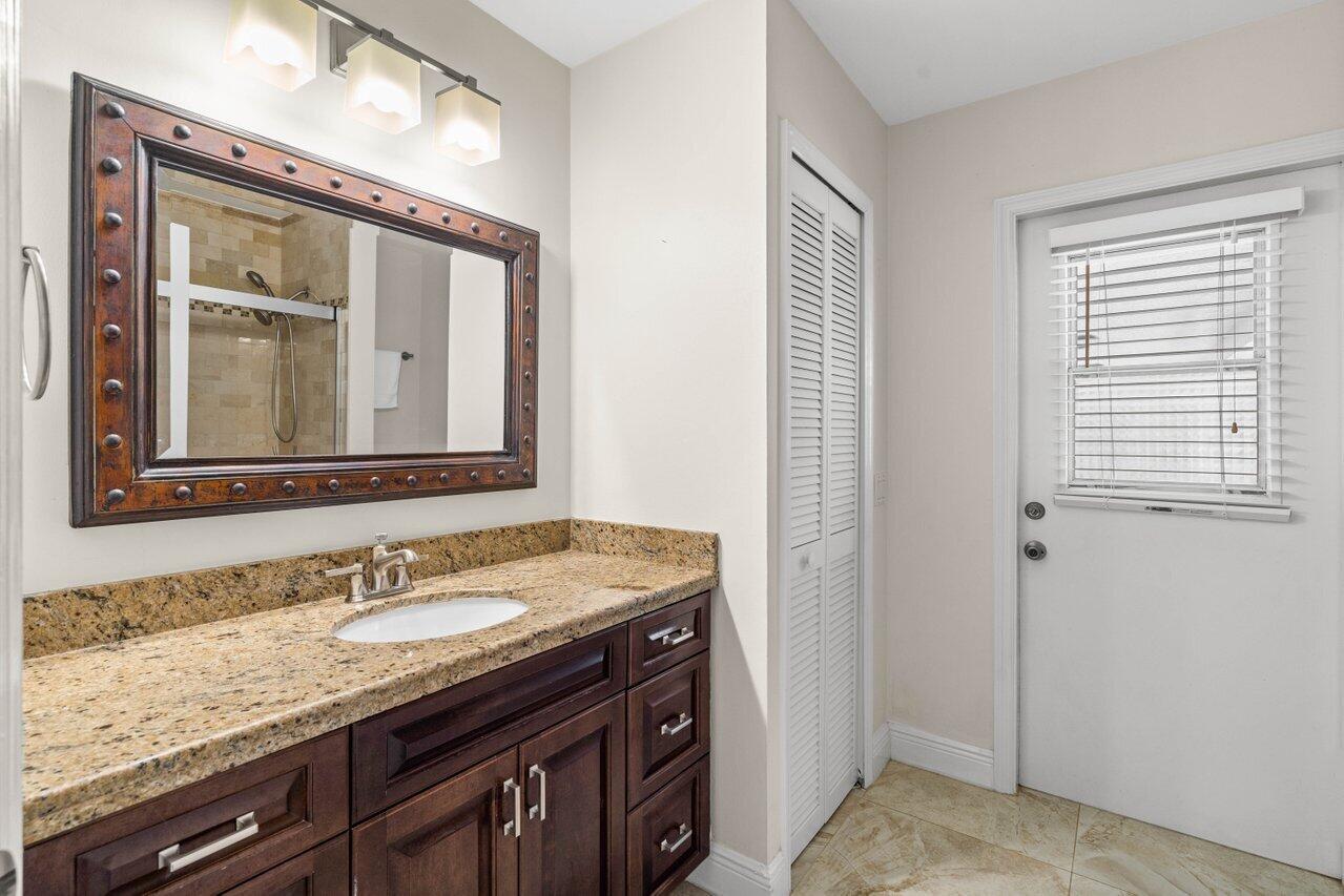 10374 Canoe Brook Circle Boca Raton, FL 33498 - Photo 20 of 41 a bathroom with a granite countertop sink and a mirror