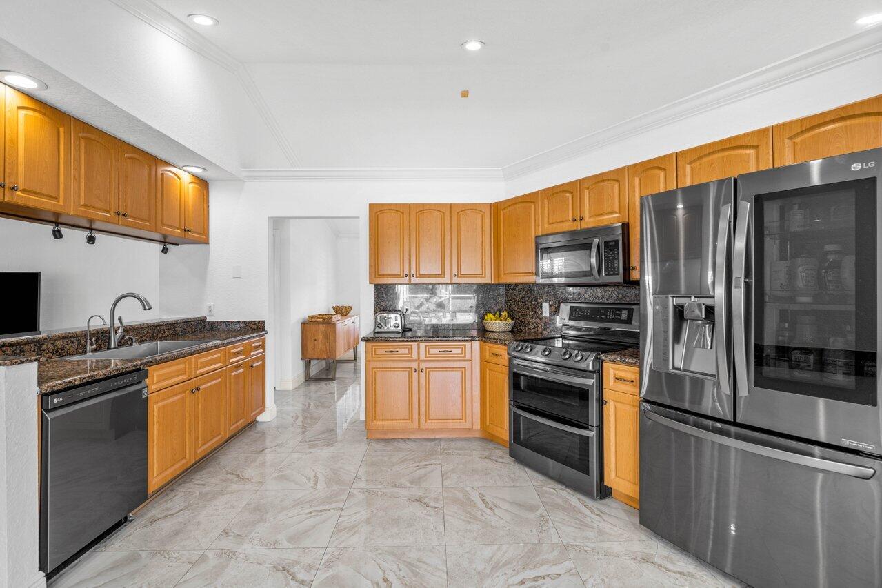 10374 Canoe Brook Circle Boca Raton, FL 33498 - Photo 22 of 41 a kitchen with stainless steel appliances granite countertop a stove top oven a sink and dishwasher