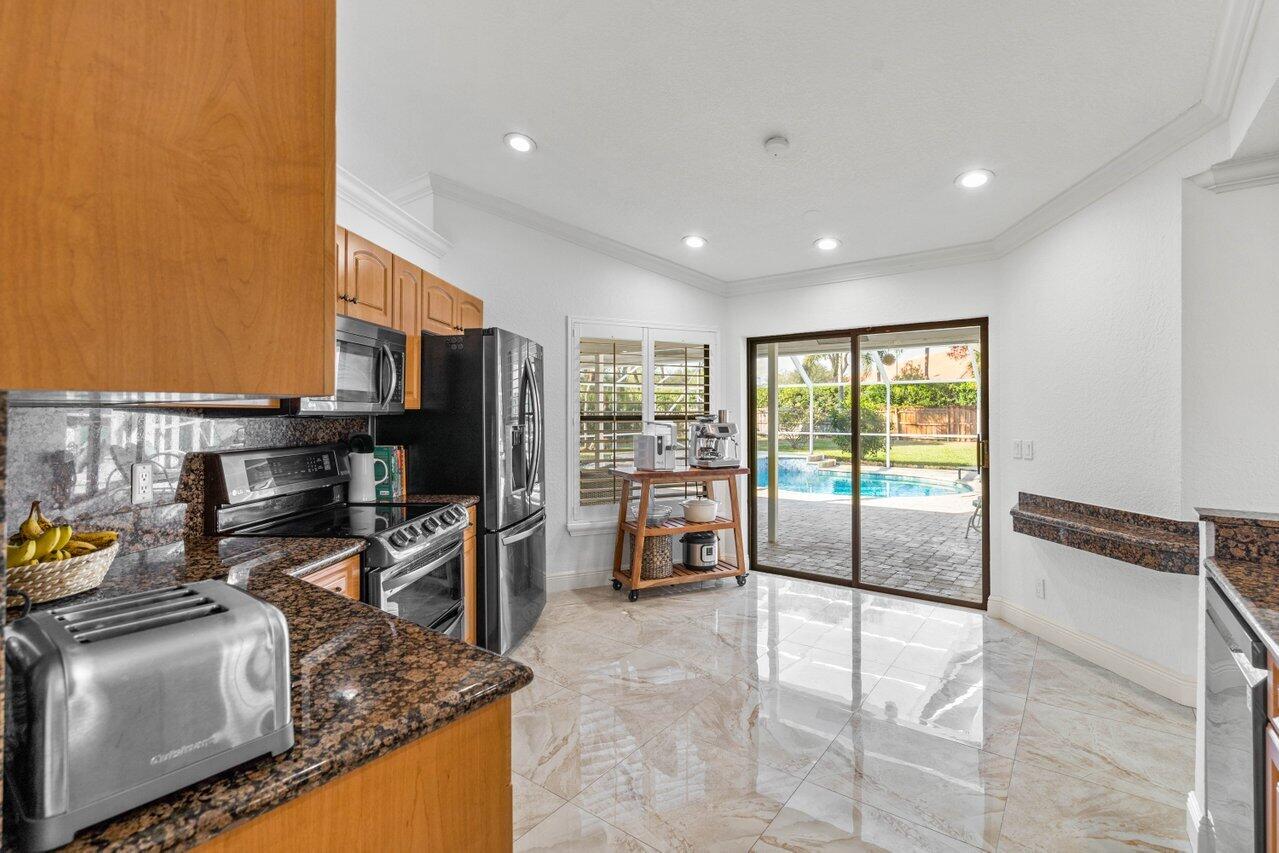 10374 Canoe Brook Circle Boca Raton, FL 33498 - Photo 23 of 41 a kitchen with stainless steel appliances granite countertop a refrigerator oven stove and a sink with granite countertops