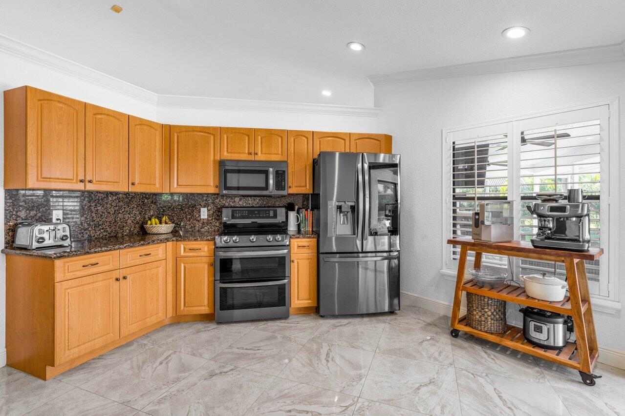 10374 Canoe Brook Circle Boca Raton, FL 33498 - Photo 25 of 41 a kitchen with stainless steel appliances granite countertop a refrigerator and a stove top oven