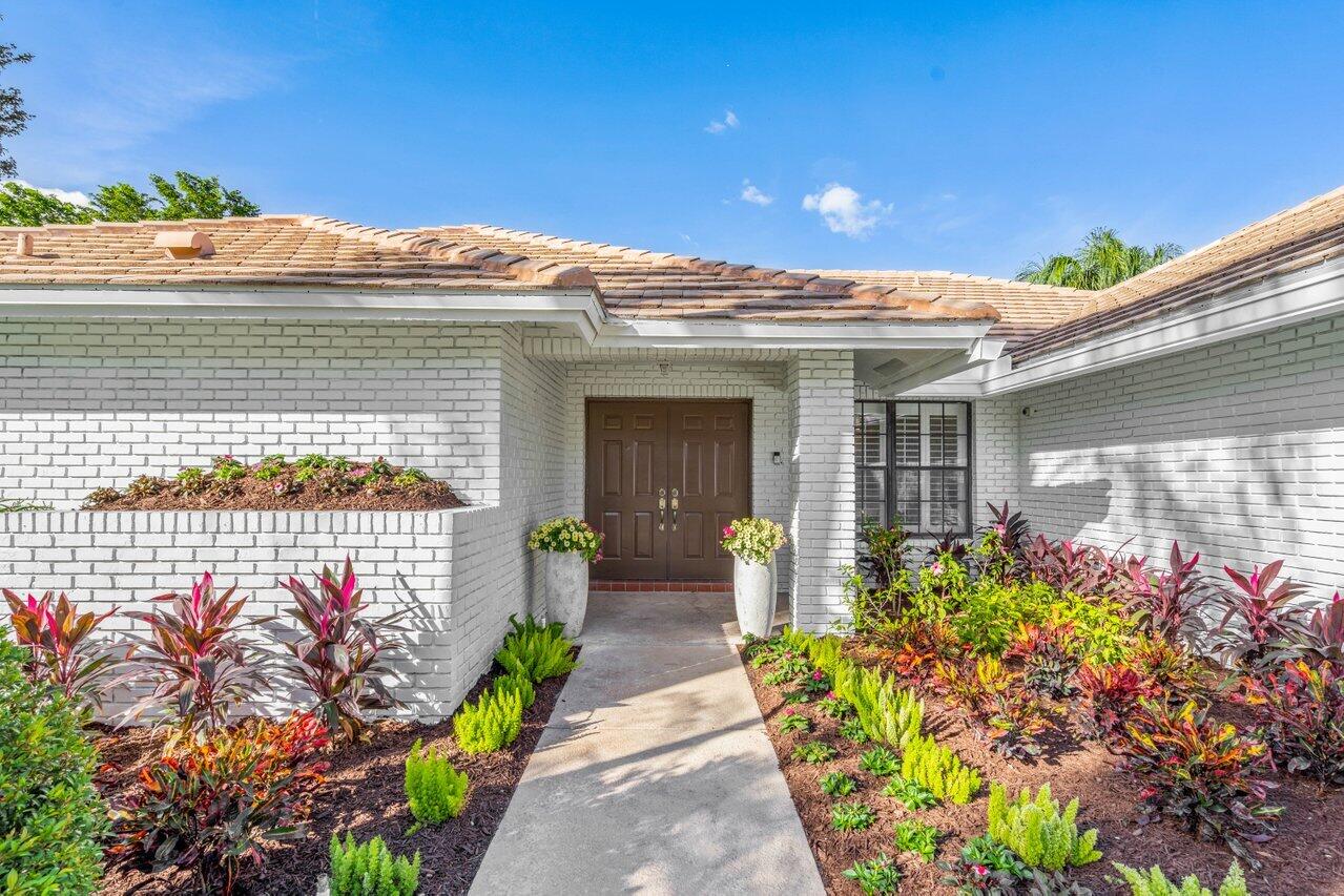 10374 Canoe Brook Circle Boca Raton, FL 33498 - Photo 3 of 41 a front view of a house with a yard and a potted plant
