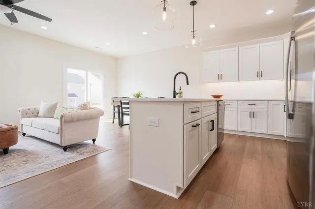 a large white kitchen with a white countertops a sink and a couch