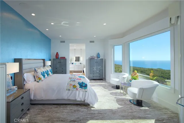 a bedroom with a bed and large windows