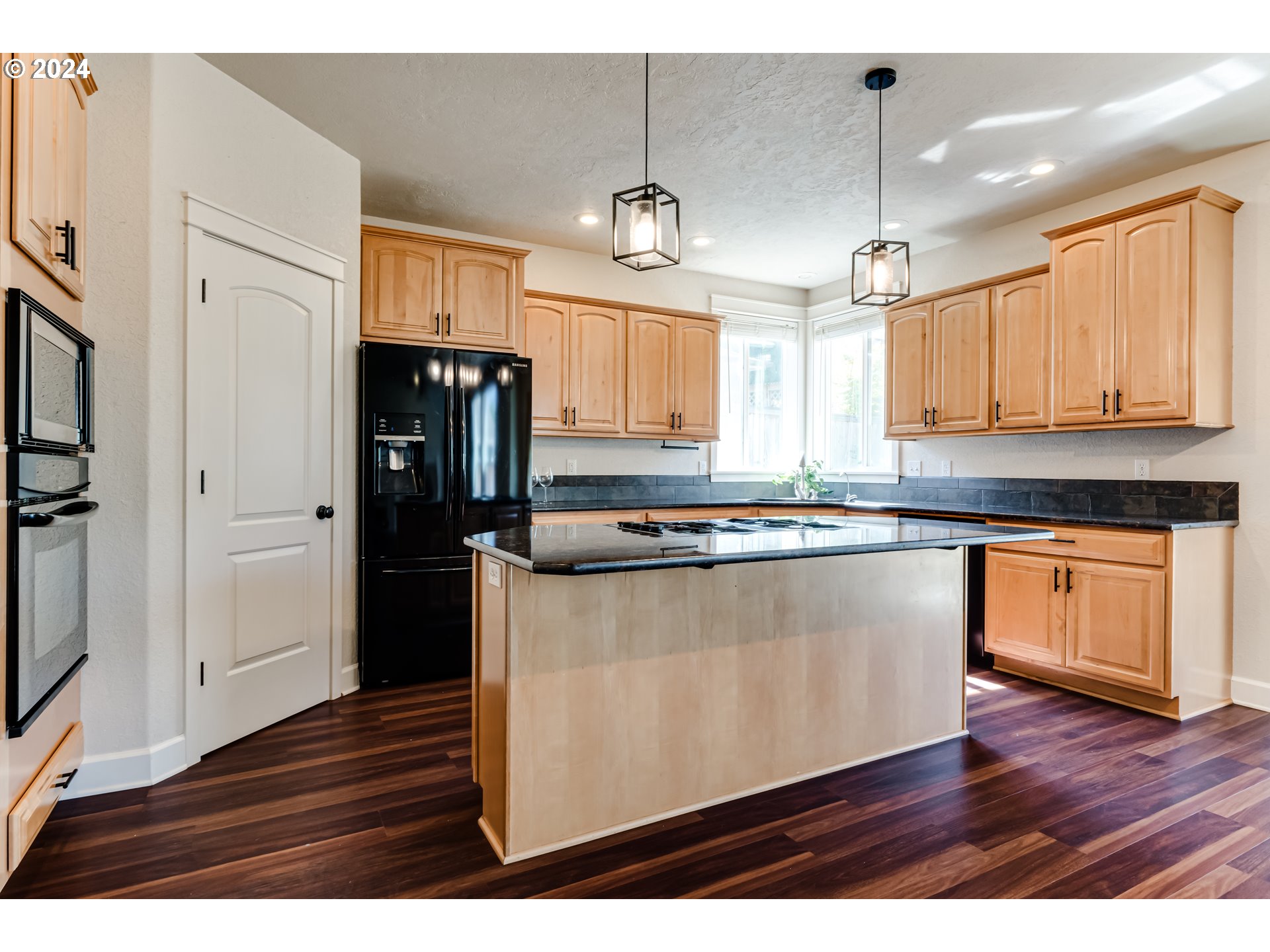 3313 Falcon Drive Springfield, OR 97477 - Photo 9 of 36 a kitchen with stainless steel appliances granite countertop a refrigerator a sink dishwasher a stove and white countertops with wooden floor
