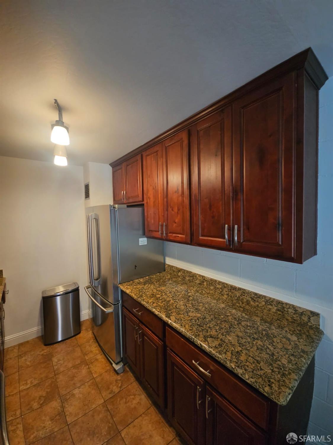 75 Western Shore Lane, Unit 1 San Francisco, CA 94115 - Photo 11 of 16 a kitchen with stainless steel appliances granite countertop wooden cabinets a refrigerator and a sink