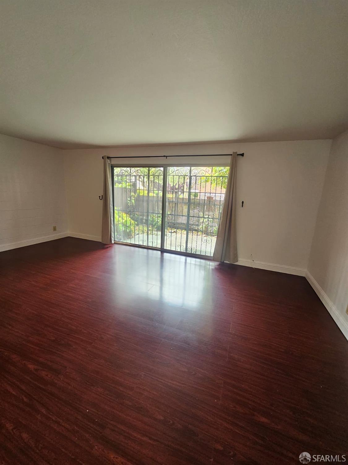 75 Western Shore Lane, Unit 1 San Francisco, CA 94115 - Photo 13 of 16 a view of an empty room with wooden floor and a window