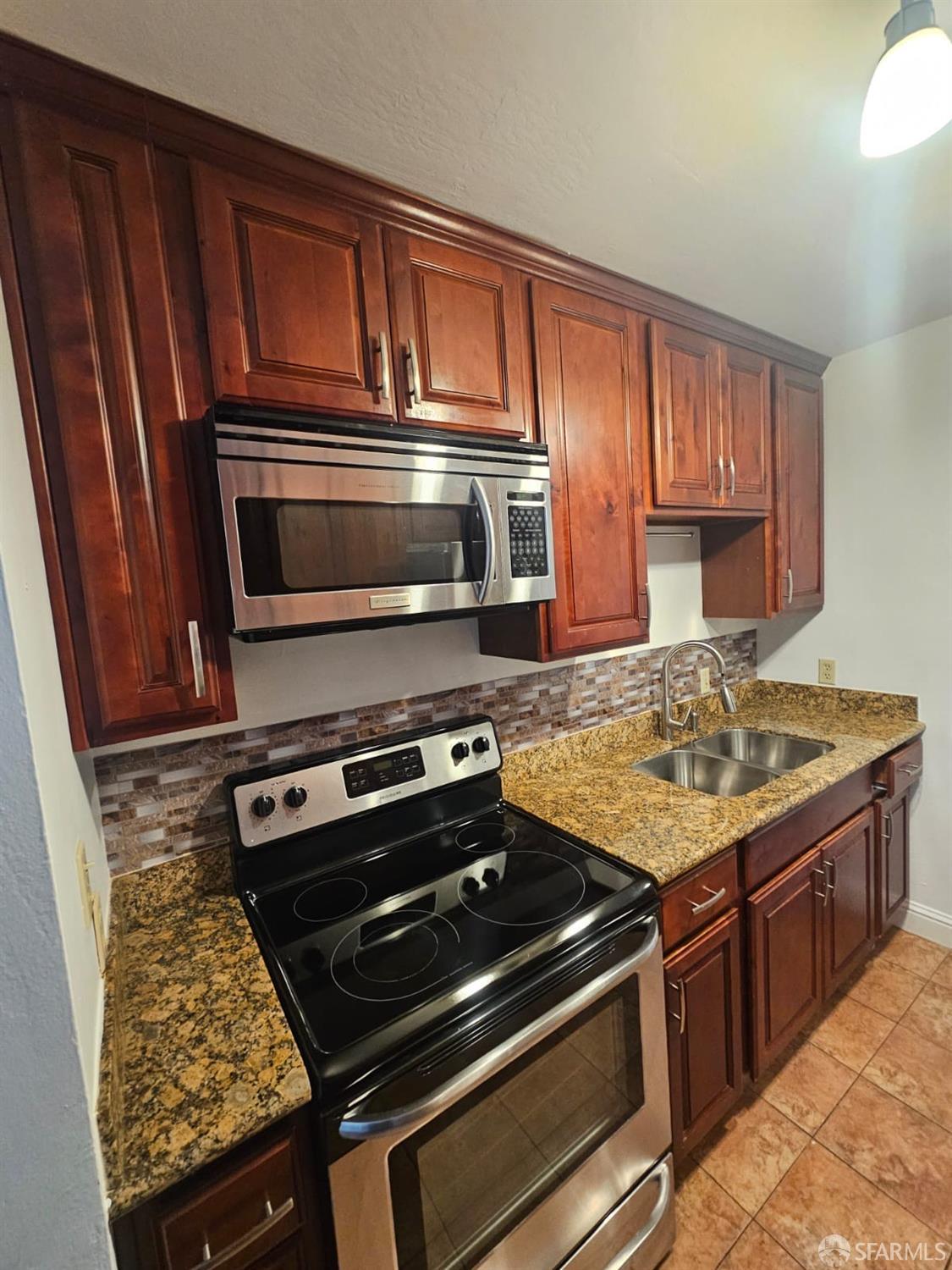 75 Western Shore Lane, Unit 1 San Francisco, CA 94115 - Photo 10 of 16 a kitchen with granite countertop a stove and a microwave