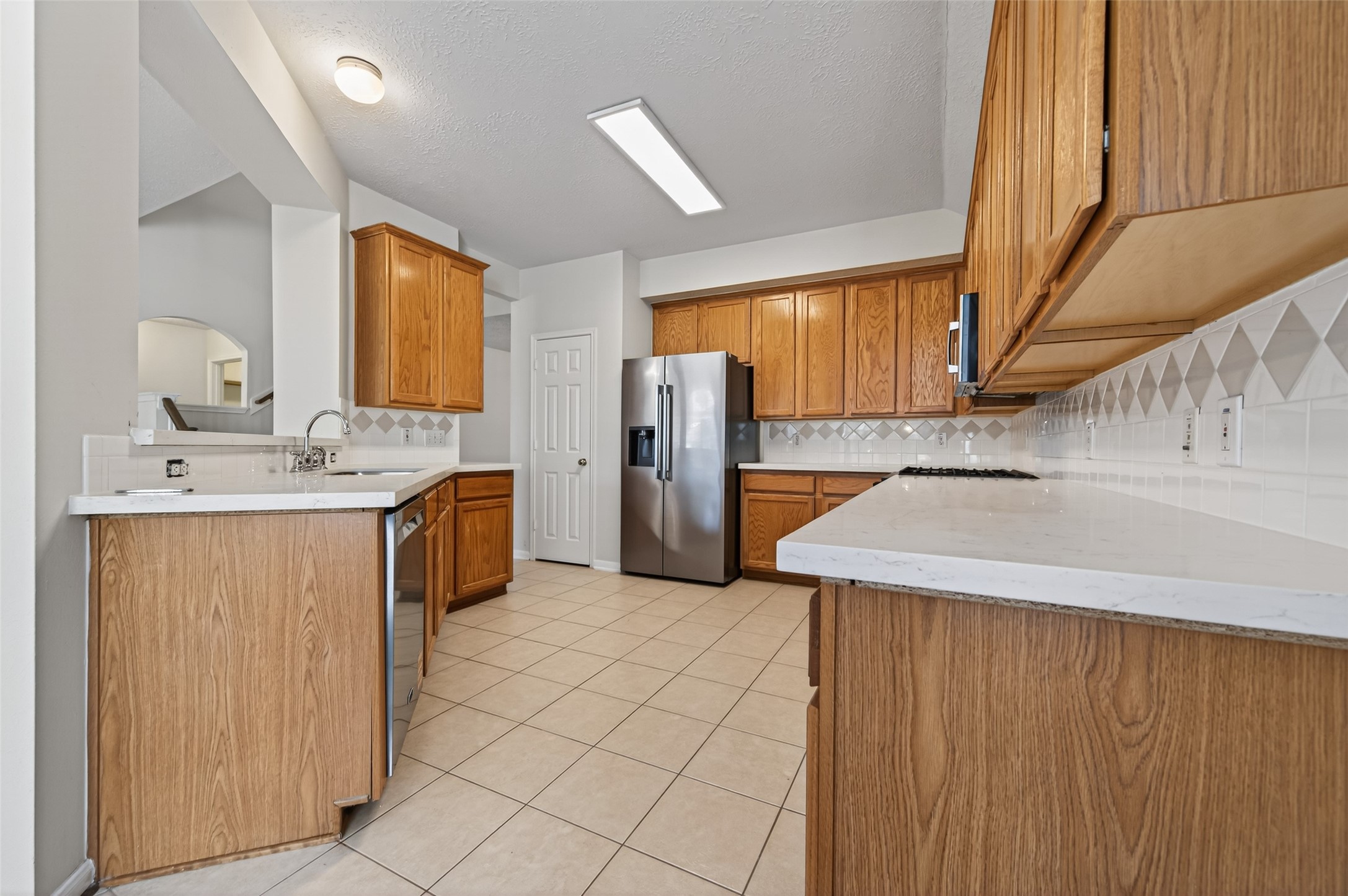 39 North Delta Mill Circle Conroe, TX 77385 - Photo 12 of 35 a kitchen with a sink a refrigerator and cabinets