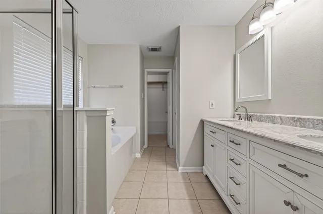 a spacious bathroom with a granite countertop sink a mirror and a shower