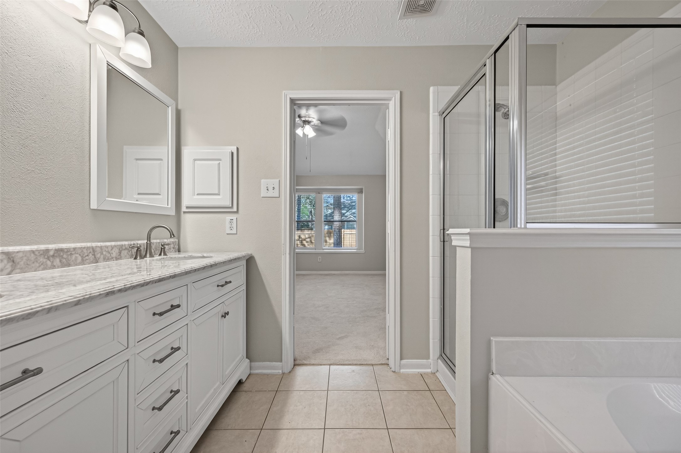 39 North Delta Mill Circle Conroe, TX 77385 - Photo 25 of 35 a bathroom with a granite countertop sink a mirror and a