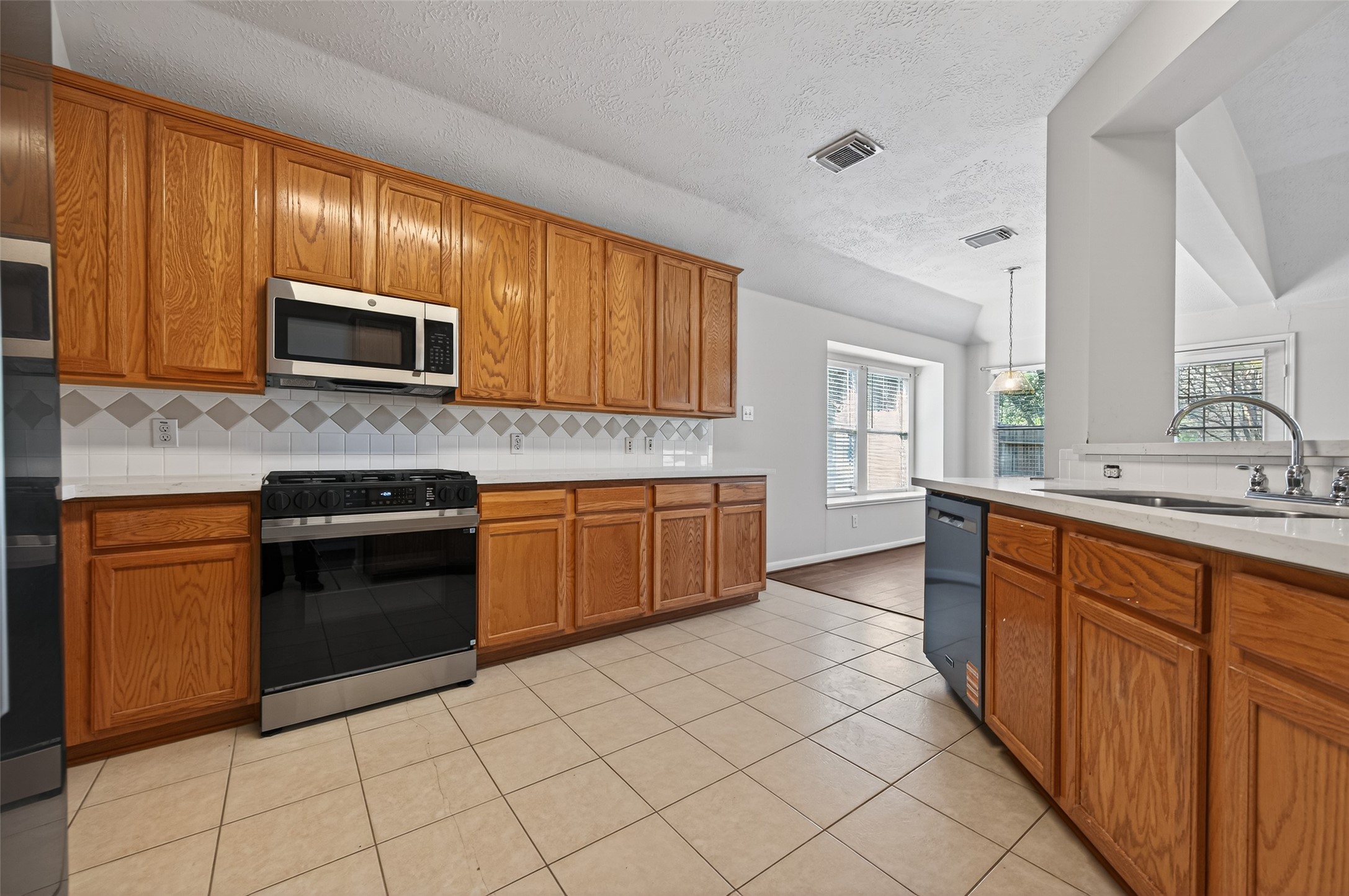39 North Delta Mill Circle Conroe, TX 77385 - Photo 8 of 35 a kitchen with stainless steel appliances granite countertop wooden cabinets a stove top oven a sink and dishwasher