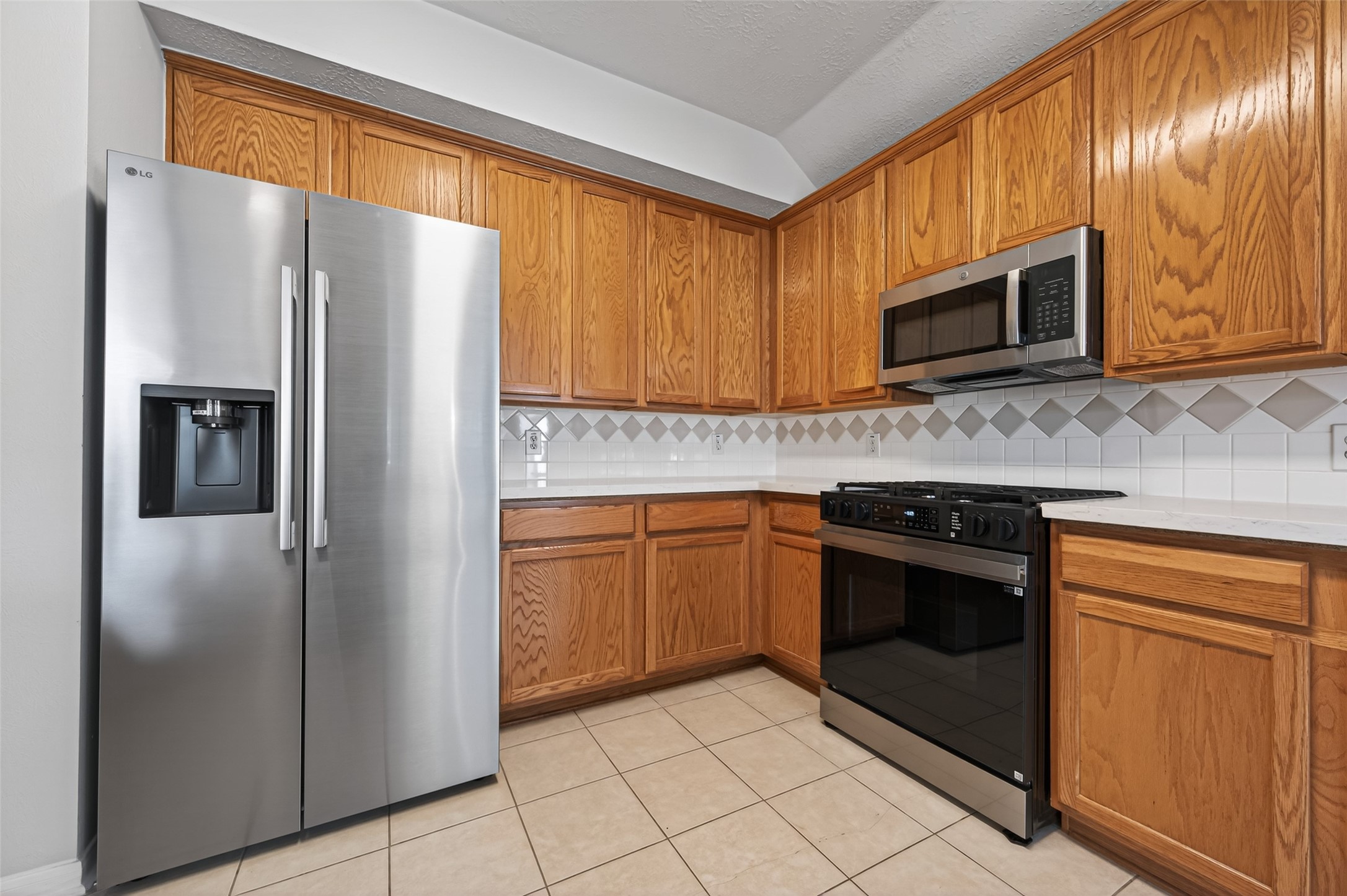 39 North Delta Mill Circle Conroe, TX 77385 - Photo 9 of 35 a kitchen with stainless steel appliances granite countertop a refrigerator stove and microwave