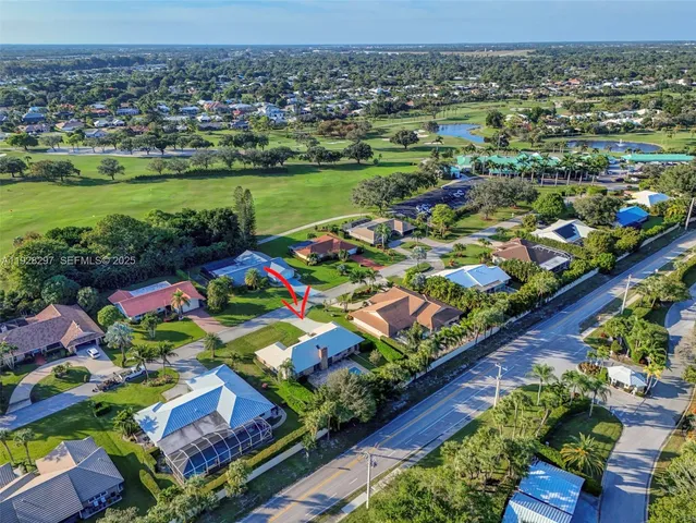 an aerial view of residential houses with outdoor space and trees