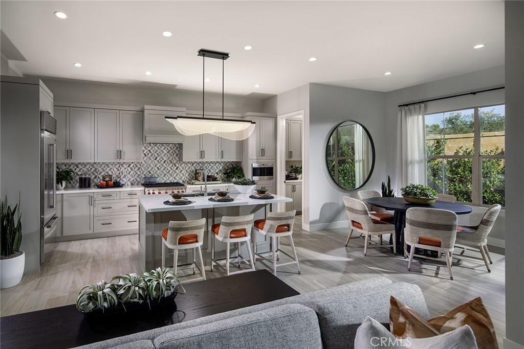 102 EVERSEDGE Irvine, CA 92618 - Photo 2 of 8 a kitchen with stainless steel appliances kitchen island granite countertop a stove a sink a dining table and chairs