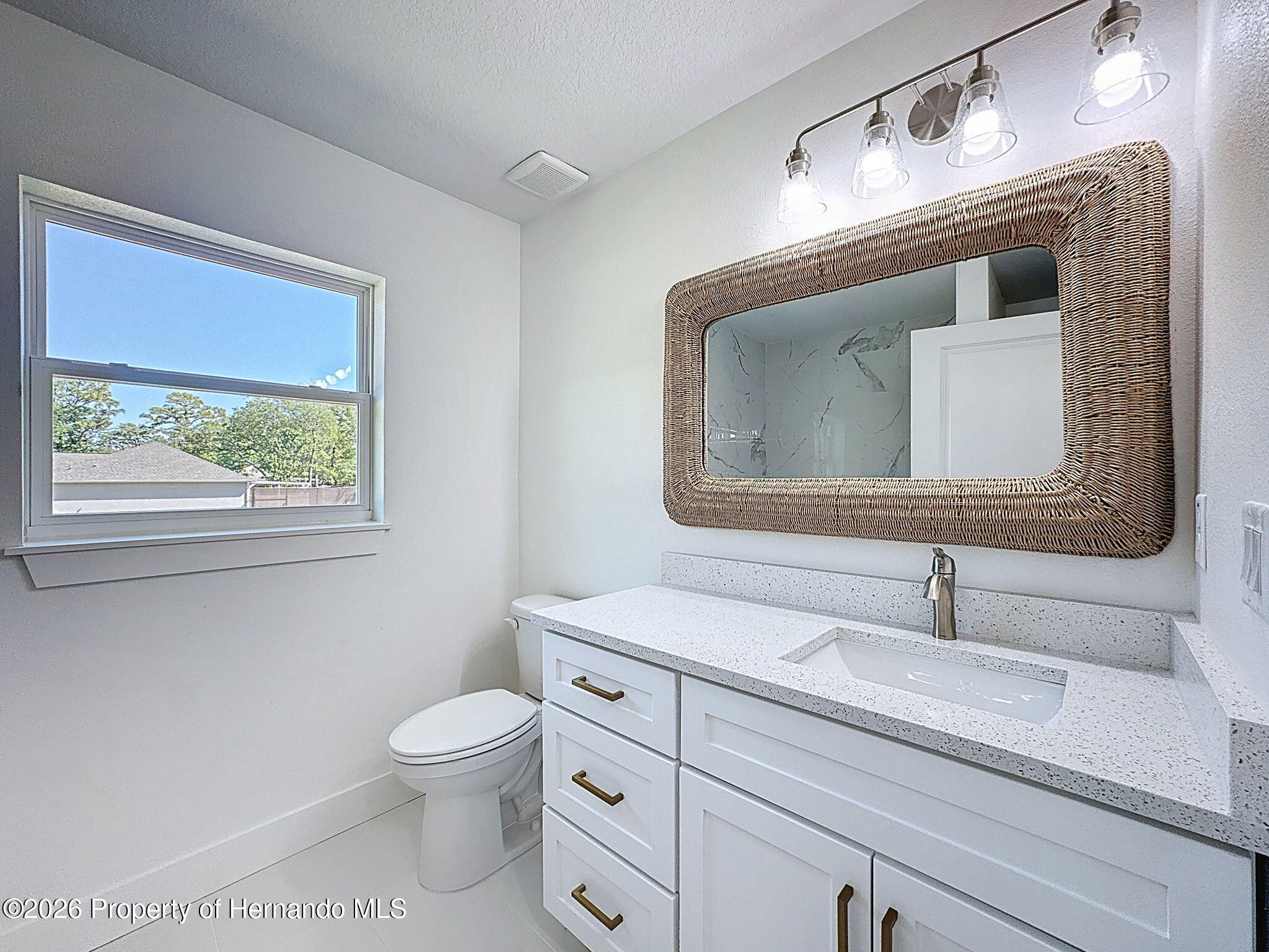 8988 Waterbird Way Weeki Wachee, FL 34613 - Photo 35 of 42 a bathroom with a toilet sink and mirror