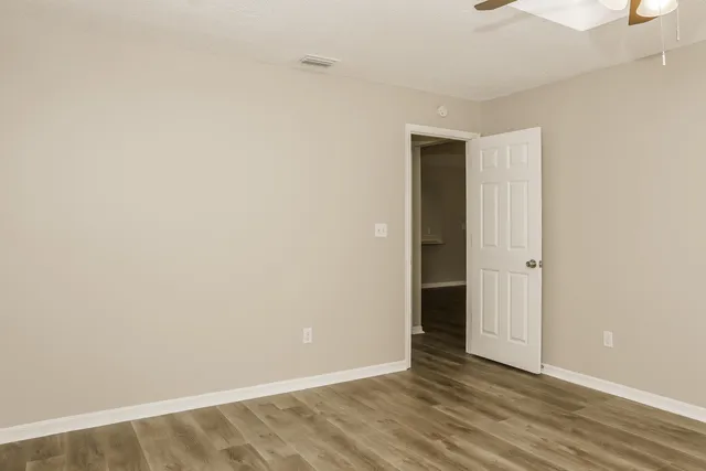 a view of an empty room with wooden floor