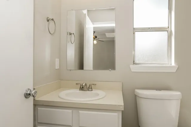 a bathroom with a sink toilet vanity and a mirror