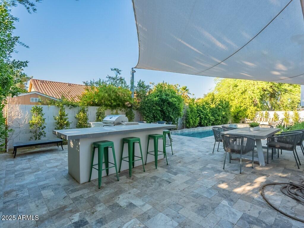 4748 East Redfield Road Phoenix, AZ 85032 - Photo 48 of 73 a view of a patio with table and chairs potted plants with wooden floor and fence
